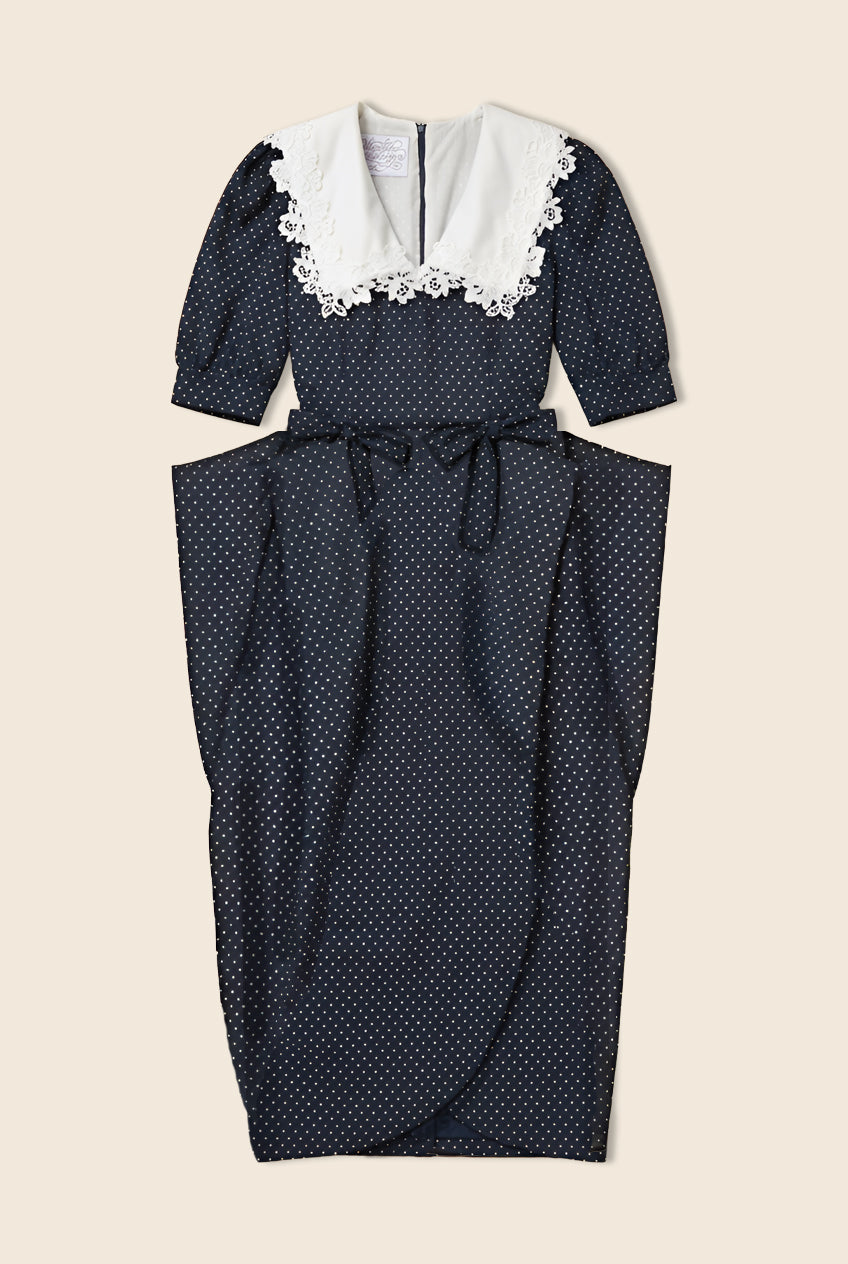 Navy polka dot dress with structure at the waist and white lace details on the collar/neckline