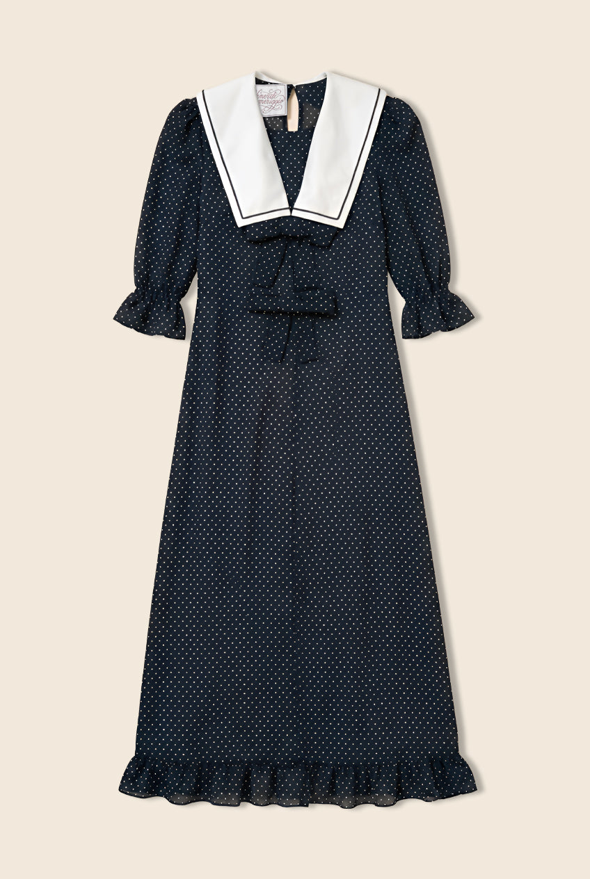 Navy polka dot dress with bows on the front and a white sailor collar 