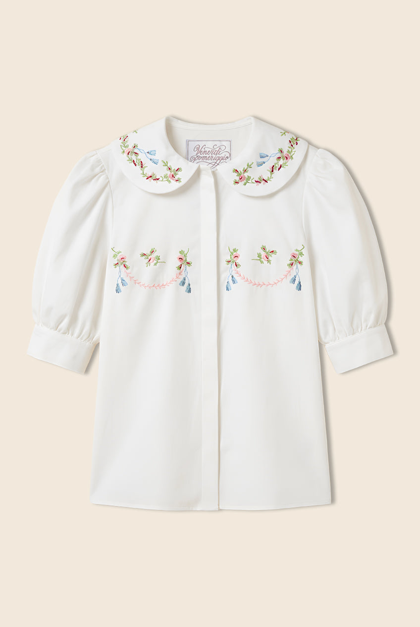 white button down  short sleeve shirt with a rounded collar and embroidery details 