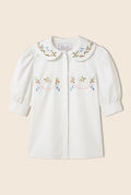 white button down  short sleeve shirt with a rounded collar and embroidery details 