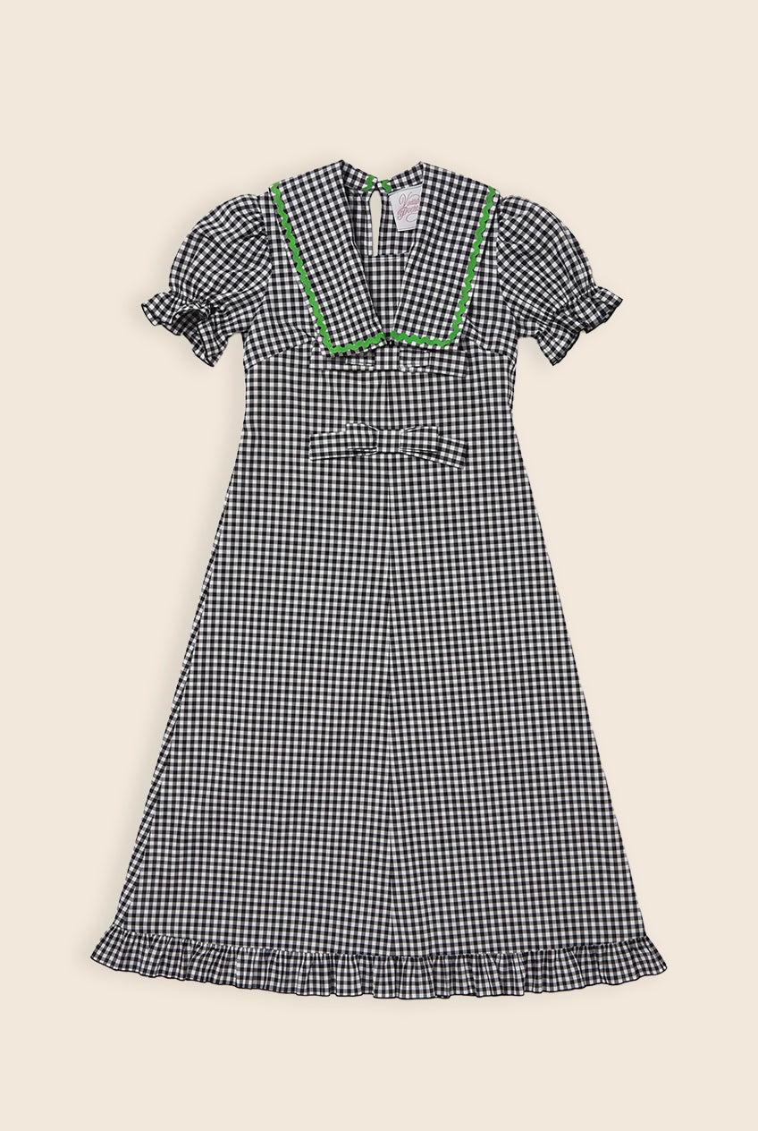 Navy blue and white checkered maxi dress with bow details and a green zig zag trim on a sailor collar