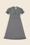 Navy blue and white checkered maxi dress with bow details and a green zig zag trim on a sailor collar